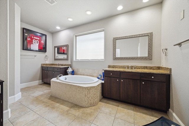 bathroom with a sink, a garden tub, two vanities, and tile patterned flooring