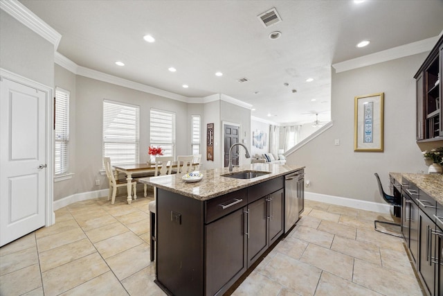 kitchen featuring visible vents, a center island with sink, crown molding, and a sink