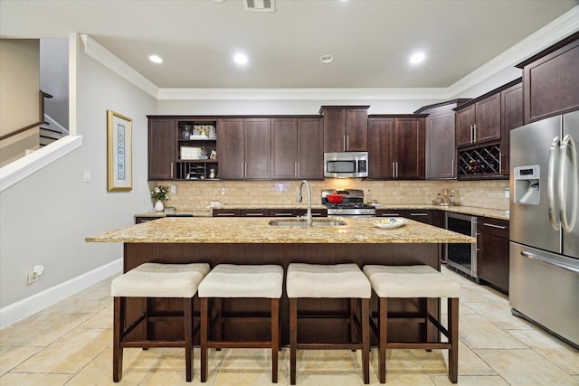 kitchen featuring a breakfast bar, beverage cooler, a sink, and stainless steel appliances