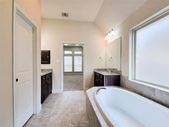 bathroom featuring a sink, visible vents, a garden tub, and two vanities