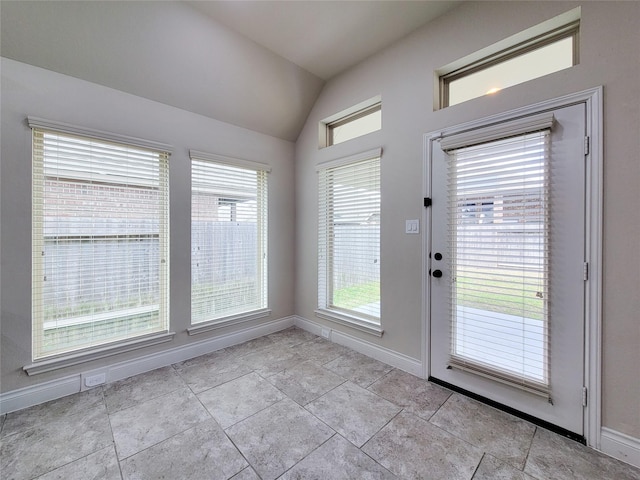 doorway featuring baseboards and vaulted ceiling