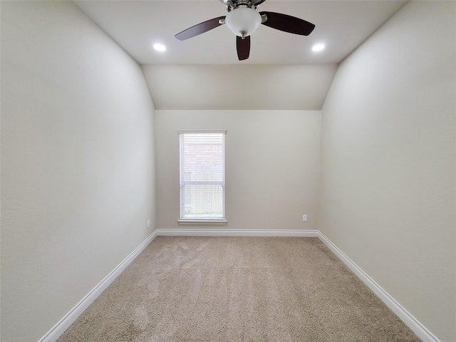 unfurnished room featuring light carpet, baseboards, ceiling fan, and vaulted ceiling