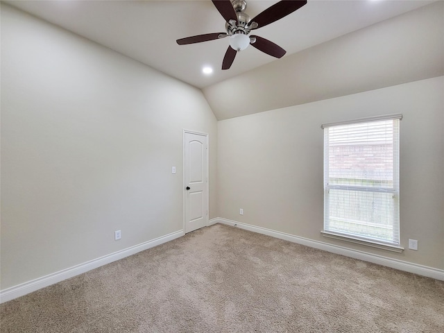 spare room with ceiling fan, baseboards, vaulted ceiling, light carpet, and recessed lighting