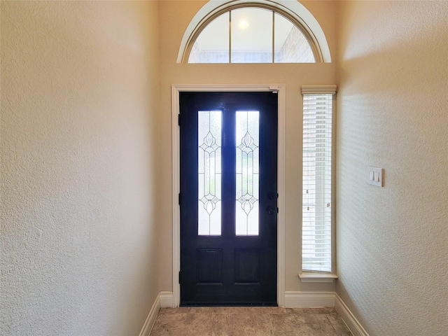 entryway with baseboards and a textured wall