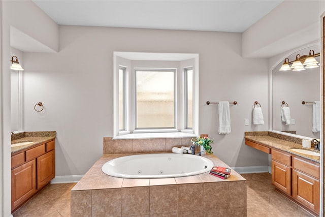 full bath featuring a sink, a jetted tub, and two vanities