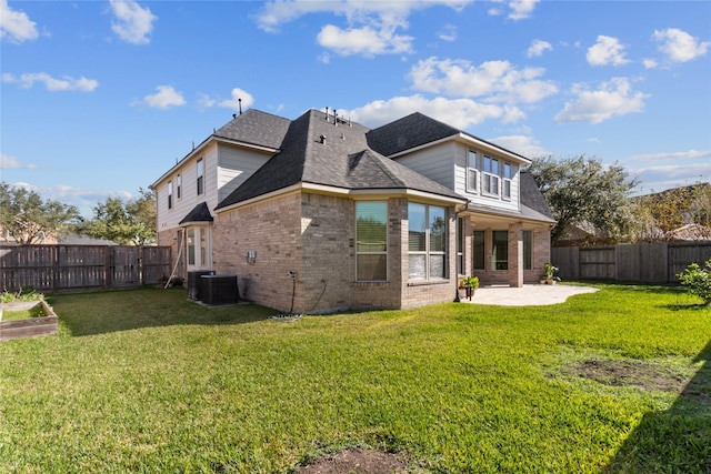 rear view of house with a patio, a lawn, brick siding, and a fenced backyard