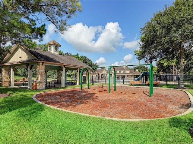 view of community featuring a gazebo, a yard, fence, and playground community