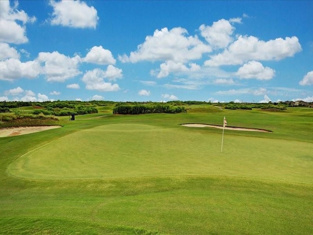 view of home's community featuring a yard and view of golf course