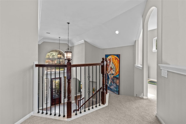 hall featuring an upstairs landing, an inviting chandelier, lofted ceiling, and carpet floors