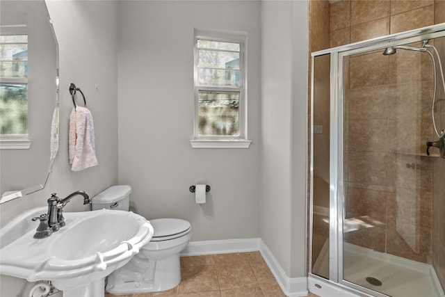 bathroom with a shower stall, toilet, tile patterned floors, and a sink