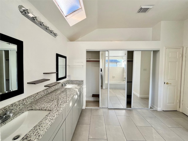 full bathroom with a shower with door, visible vents, lofted ceiling with skylight, tile patterned floors, and a sink