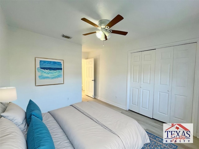 bedroom with visible vents, wood finished floors, a closet, baseboards, and ceiling fan