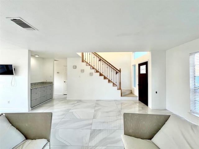 living room with visible vents, stairs, and baseboards