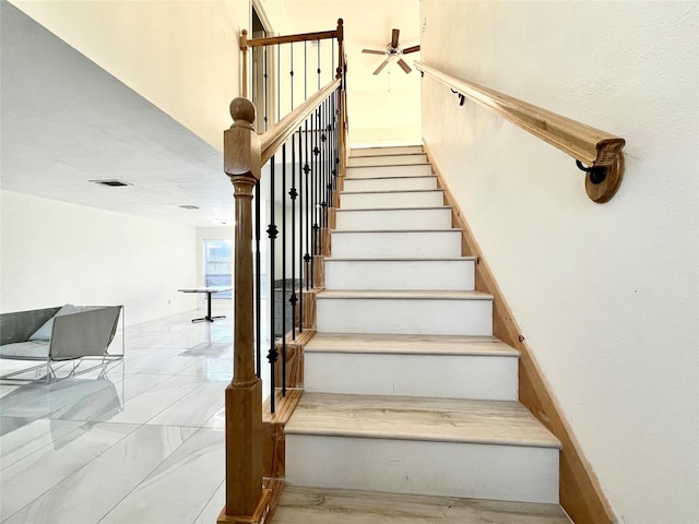 stairway with a ceiling fan and visible vents