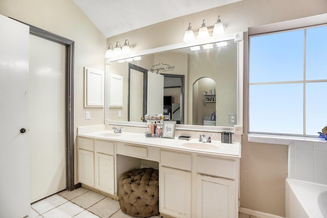 bathroom featuring double vanity, lofted ceiling, a tub, a sink, and tile patterned floors