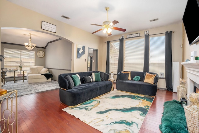 living area featuring ceiling fan with notable chandelier, visible vents, arched walkways, and hardwood / wood-style floors