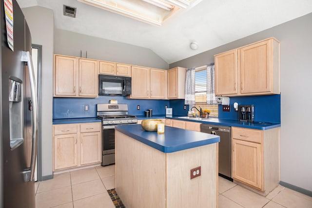 kitchen with light tile patterned floors, appliances with stainless steel finishes, light brown cabinets, and a sink