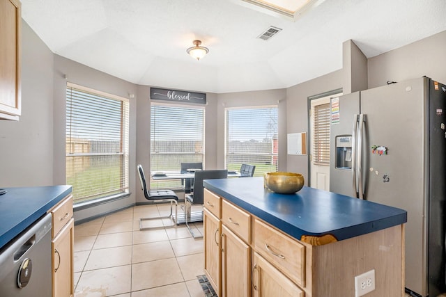 kitchen featuring dark countertops, visible vents, light brown cabinets, light tile patterned floors, and stainless steel appliances