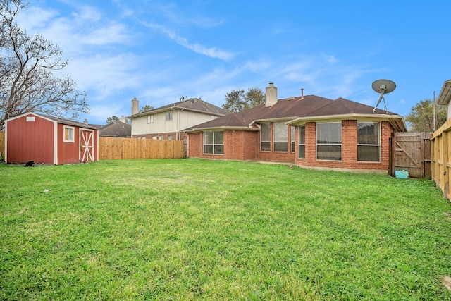 rear view of property with a storage unit, an outbuilding, a lawn, a fenced backyard, and brick siding