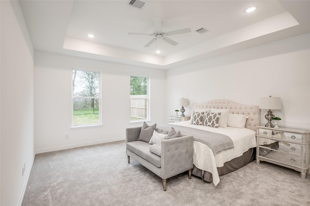 bedroom featuring visible vents, carpet, and a tray ceiling