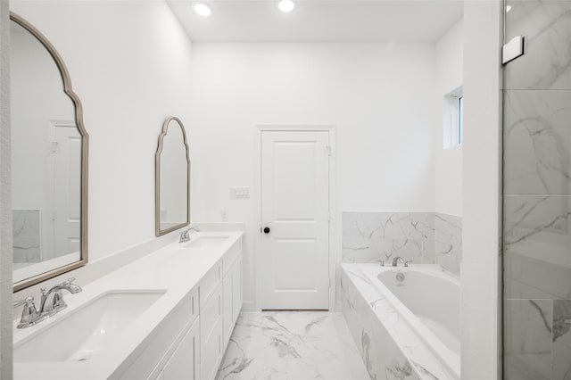 bathroom featuring a garden tub, double vanity, marble finish floor, and a sink