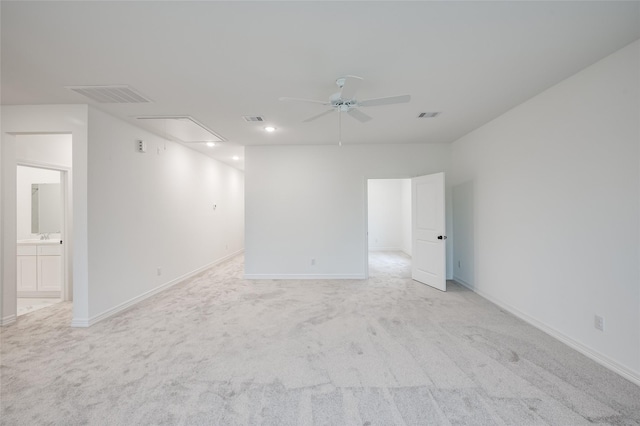 empty room with a ceiling fan, attic access, light colored carpet, and visible vents