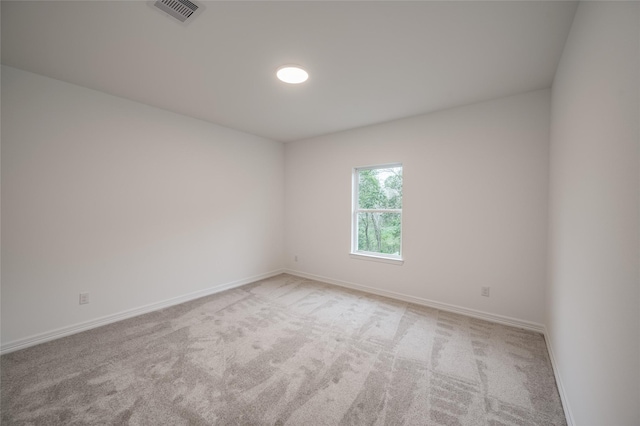 spare room with visible vents, carpet floors, and baseboards