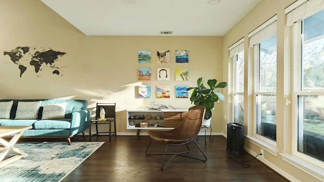 sitting room with dark wood-style floors, visible vents, and baseboards