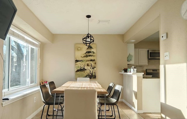 dining space with light tile patterned floors and baseboards