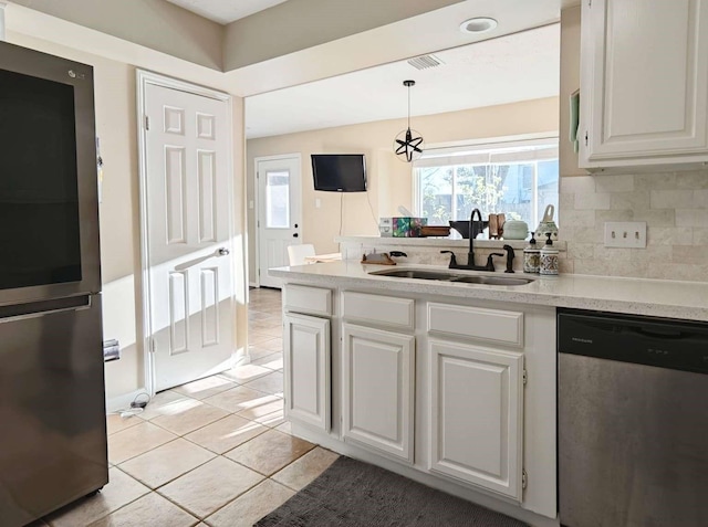 kitchen with visible vents, a sink, appliances with stainless steel finishes, white cabinetry, and tasteful backsplash