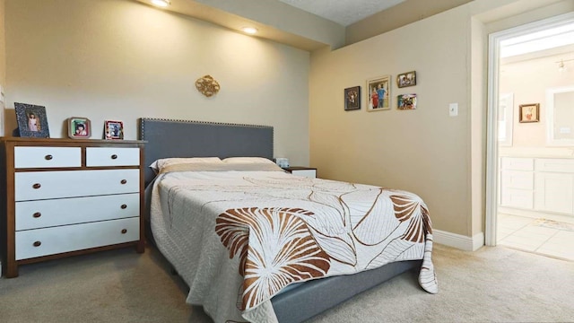 carpeted bedroom with baseboards and ensuite bathroom