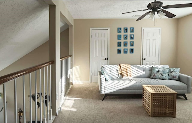 carpeted living room featuring a textured ceiling and ceiling fan