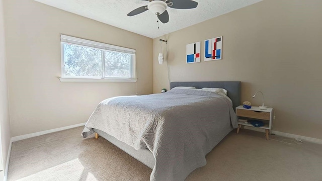 bedroom with ceiling fan, a textured ceiling, baseboards, and carpet