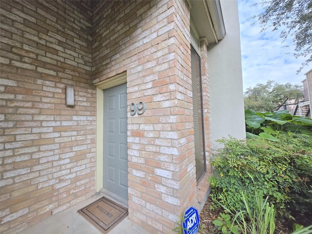 view of exterior entry with brick siding