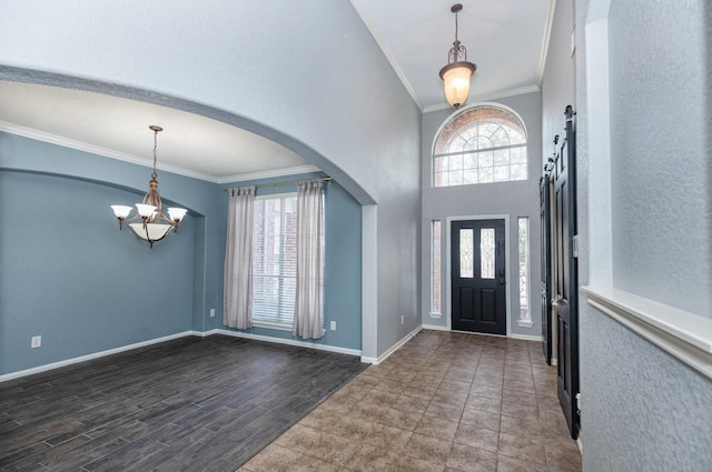 entrance foyer featuring a wealth of natural light, a chandelier, and crown molding