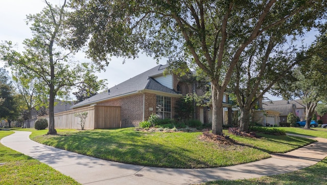 view of side of property featuring brick siding and a lawn