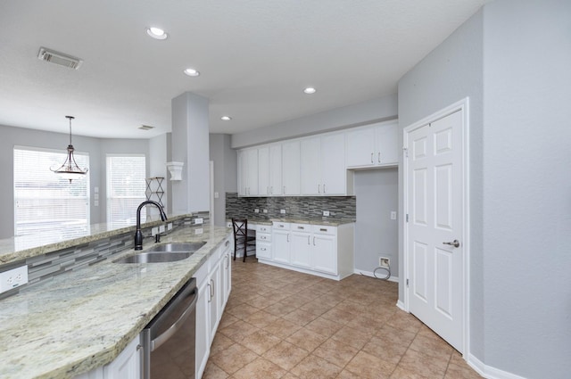 kitchen with stainless steel dishwasher, decorative backsplash, white cabinetry, and a sink