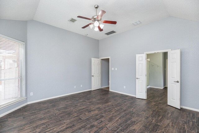 unfurnished bedroom with visible vents, dark wood-style floors, and vaulted ceiling