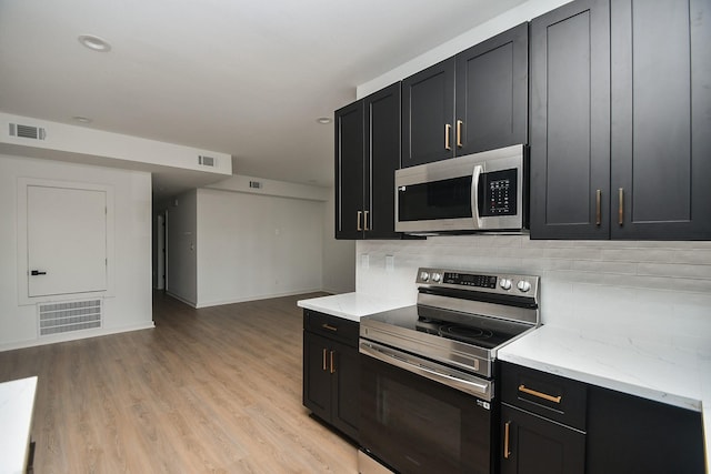 kitchen with dark cabinetry, visible vents, and appliances with stainless steel finishes