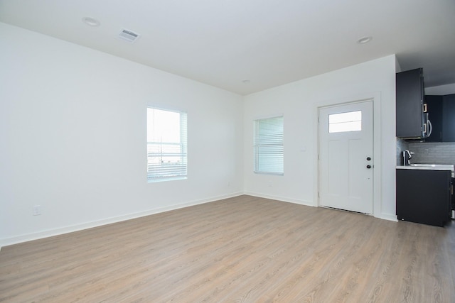 entrance foyer featuring light wood finished floors, visible vents, and baseboards