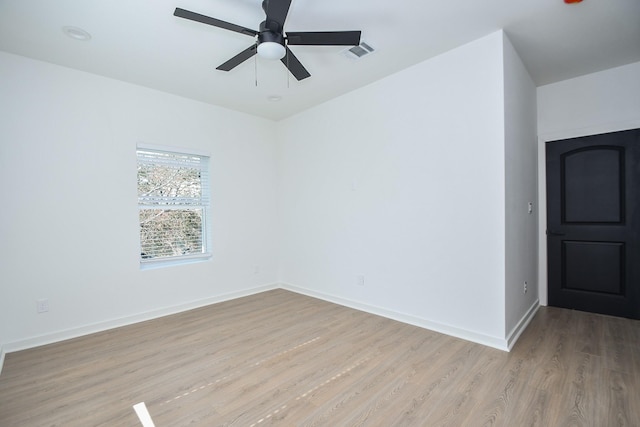 empty room with visible vents, ceiling fan, light wood-type flooring, and baseboards