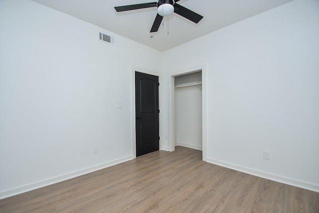 unfurnished bedroom with visible vents, baseboards, light wood-style floors, and a closet