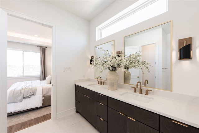 ensuite bathroom featuring ensuite bath, a wealth of natural light, and a sink