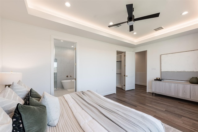 bedroom with visible vents, wood finished floors, recessed lighting, baseboards, and a raised ceiling