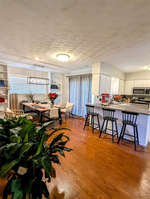 dining room with built in shelves and wood finished floors