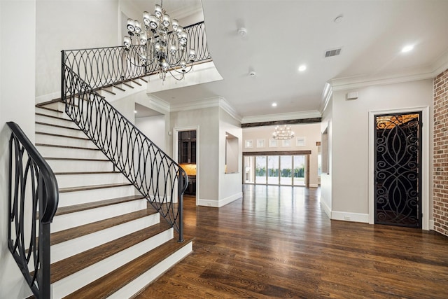 foyer entrance featuring baseboards, wood finished floors, visible vents, and a chandelier