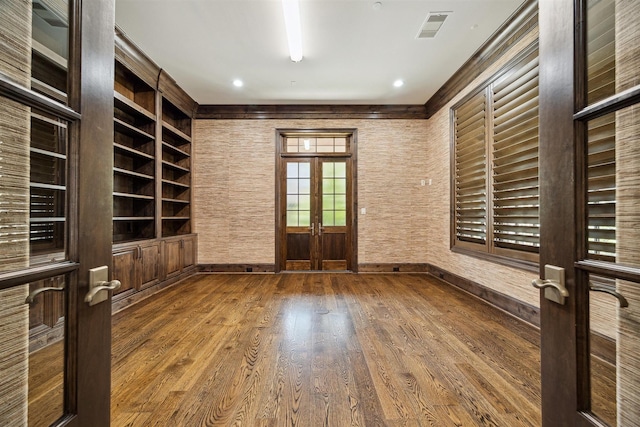 interior space featuring visible vents, built in shelves, baseboards, french doors, and wood finished floors