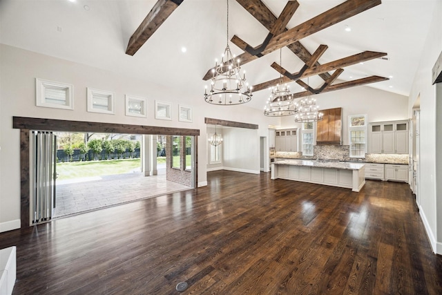 unfurnished living room with baseboards, a chandelier, beamed ceiling, dark wood finished floors, and high vaulted ceiling