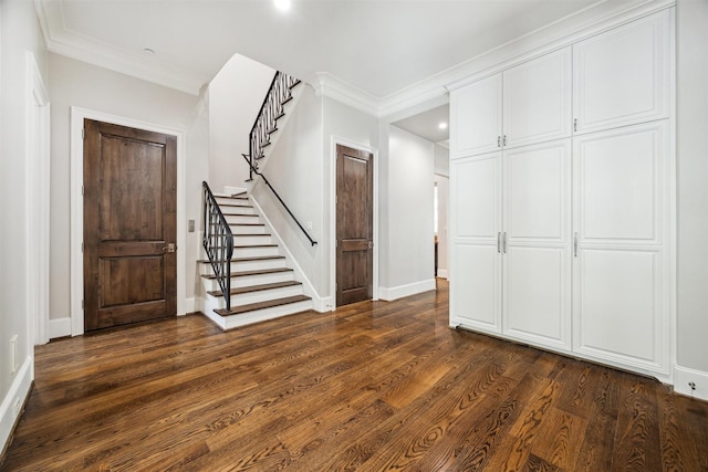 entryway with stairs, crown molding, dark wood-style floors, and baseboards