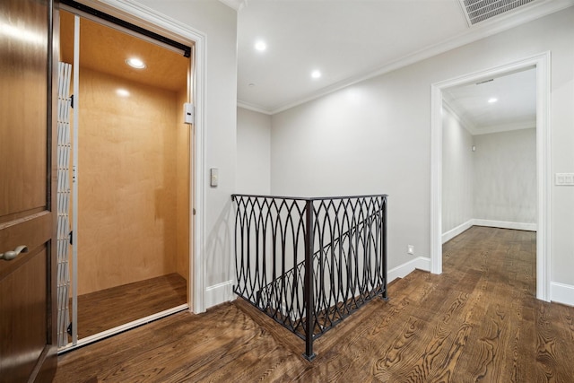 hall with crown molding, dark wood-style floors, an upstairs landing, and visible vents